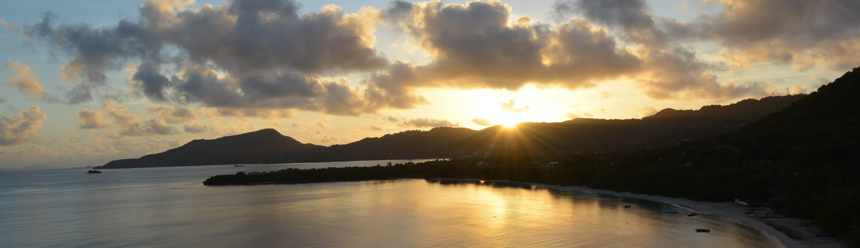 Golden sunset over Carriacou's coastline and Paradise Beach bay viewed from Las Tortugas Villa, Grenadines